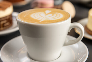 Taza de café con arte latte en primer plano con foco selectivo.  