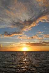 Beautiful yellow sunset over the ocean and different color sky