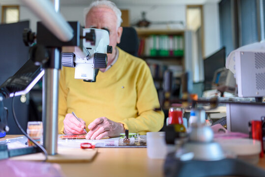 Arbeiten im Alter - Ein Senior arbeitet in seiner Elektronik-Werkstatt.