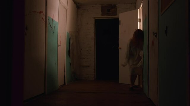 Horror acting - a woman in a straitjacket broke out of the room in mental hospital and walking to the camera
