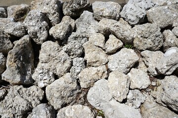 Pile of irregular coarse stones abstract horizontal background pattern