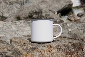 Blank enamel coffee cup mockup, empty camping mug in wild nature for design presentation,
