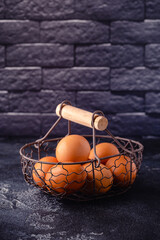Fresh raw eggs in a metal basket.
