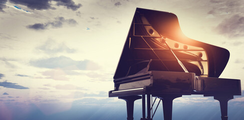 Grand piano on sunset sky background