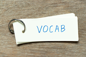 Flash card with handwriting word vocab on wood background