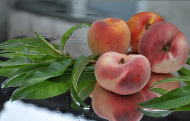 Ripe peaches with leaves. Fig peach. Nectarine. Saturn Peaches. flat peach