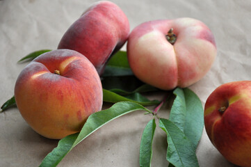 Ripe peaches with leaves. Fig peach. Nectarine. Saturn Peaches. flat peach