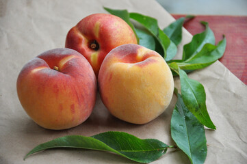 Ripe peaches with leaves. Fig peach. Nectarine. Saturn Peaches. flat peach