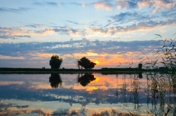 Early sunrise over the river reflection in the river in summer