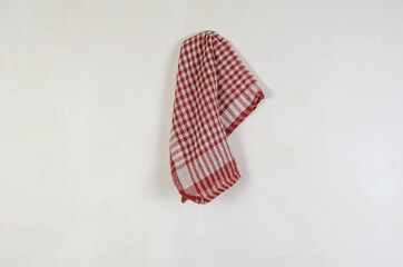 Red checkered napkin against a gray wall. Cotton napkin hanging