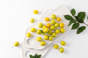 yellow freshly torn cherry plum on a white background, top view