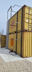 Containers in the field. Welder during work