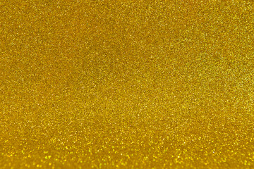 Background from orange glitter foam with a bend. Brilliant bokeh. Festive decoration. Christmas or Helloween gold pattern.