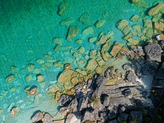 Aerial view of a crystal clear see through turquoise water, white sand beach and green pine trees forest, straight down perspective. Shot with drone. Space for copy. Georgian Bay, Bruce Peninsula.