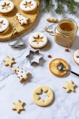 Fototapeta premium Traditional Austrian Christmas cookies. Linzer Christmas or New Year cookies filled with peanut butter on a marble top.