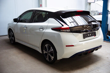 Back view photo of white electro car standing on repair station service