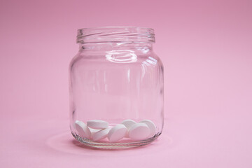 homeopathic globules and glass bottle close up on pink background. Alternative Homeopathy medicine herbs, healtcare and pills concept. Flatlay. copyspace for text.
