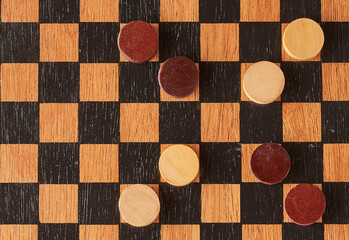 top view of checkers game board with pieces in cross