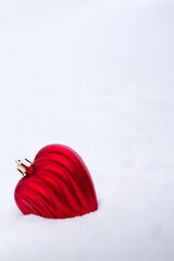 Red heart in white snow.Valentines day background.