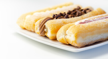 Mixed finger donuts filling chocolate, custard, jam and whipped cream, eclairs in different flavors