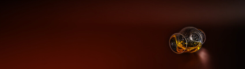 Expensive single malt whisky in a tasting glass on the burgundy background