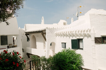 View of the alleys and white architecture and buildings of the fishing village of Binibeca Vell, Menorca, Spain during summer season.