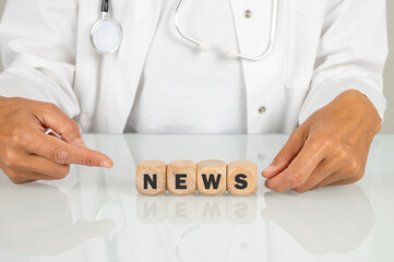 Ärztin am Schreibtisch in der Arztpraxis und dem Schlagwort NEWS