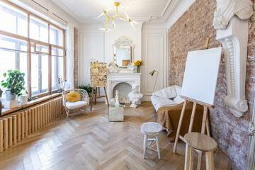 bright workshop room for the creation and work of an architect and artist in a loft style with brick walls and parquet. the walls are decorated with examples of stucco.