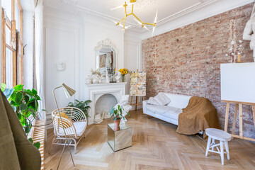 bright workshop room for the creation and work of an architect and artist in a loft style with brick walls and parquet. the walls are decorated with examples of stucco.