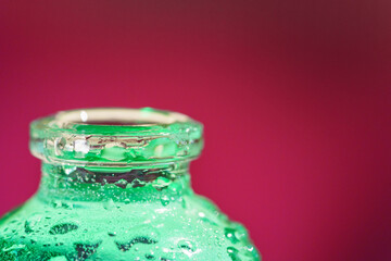 bouteille verte en vert glacée sur fond rouge