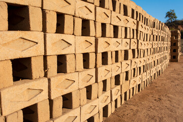 Hand made bricks from wet clay and mud are kept for drying before the burning process. Traditional production of clay bricks in India.