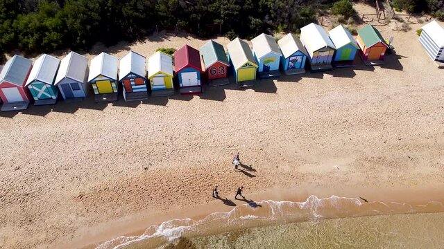 Aerial - drone shot of a row of bright and colorful beach shacks, Australia