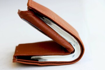 Brown leather wallet with money on floor