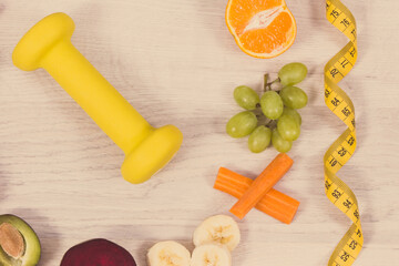 Fuits and vegetables, dumbbell and tape measure, concept of nutritious food, healthy lifestyles and slimming