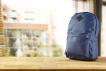School backpack on table and window background 