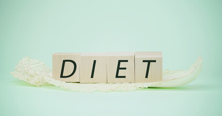 Green cabbage leaf and text diet on light background