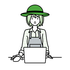 デスクで座ってPCを使っている農家の女性
