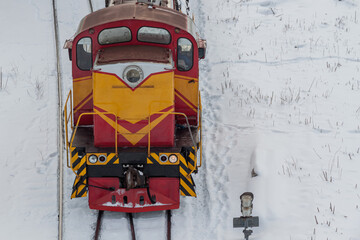 Diesel shunting locomotive at a snow-covered railway station. The concept of railway transportation.