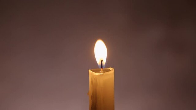 A burning candle on a dark background. .Macro