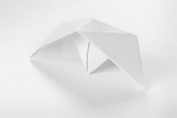 White capsized paper boat or Origami boat on white background.

