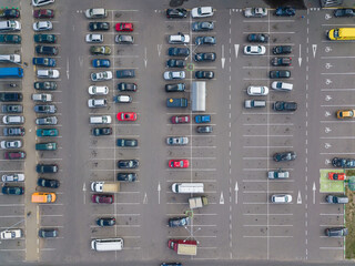 Drone view of a large car parking lot on a sunny summer day, horizontal car parking