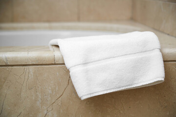 white clean foot towel on the edge of the bathroom