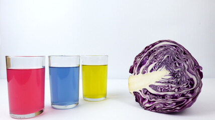 Red cabbage and three glasses filled with colored liquid. Make a measure of the pH (power of...