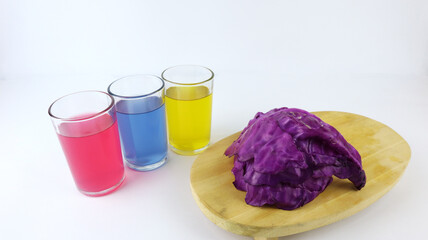 Red cabbage and three glasses filled with colored liquid. Make a measure of the pH (power of...