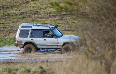 Obraz na płótnie Canvas 4x4 land rover discovery series II off roading, wading in deep water and slippery mud
