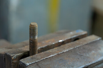 Close-up of a bolt in a metal clip in a garage workshop