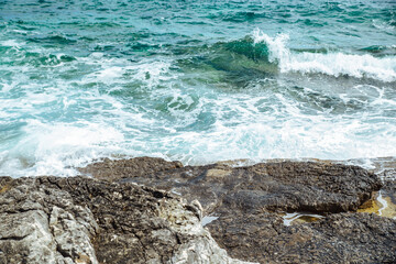 view of water with waves with rocky cliff