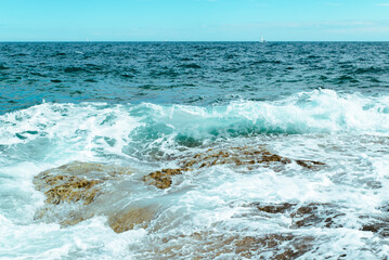 view of rocky seaside waves with white foam