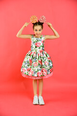Happy smiling girl with sweets on a pink background, a holiday