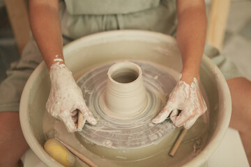 Fototapeta na wymiar Potter with cutting thread making clay vessel